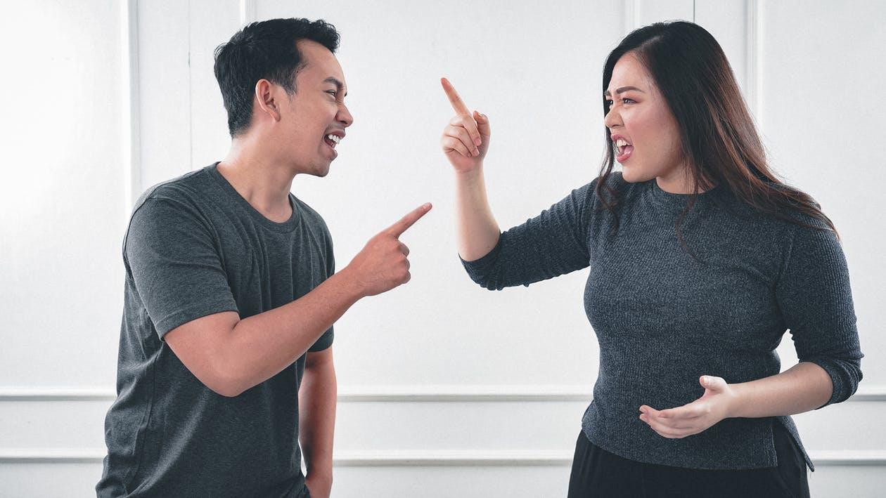 Free A Man and Woman Arguing while Pointing Fingers Stock Photo