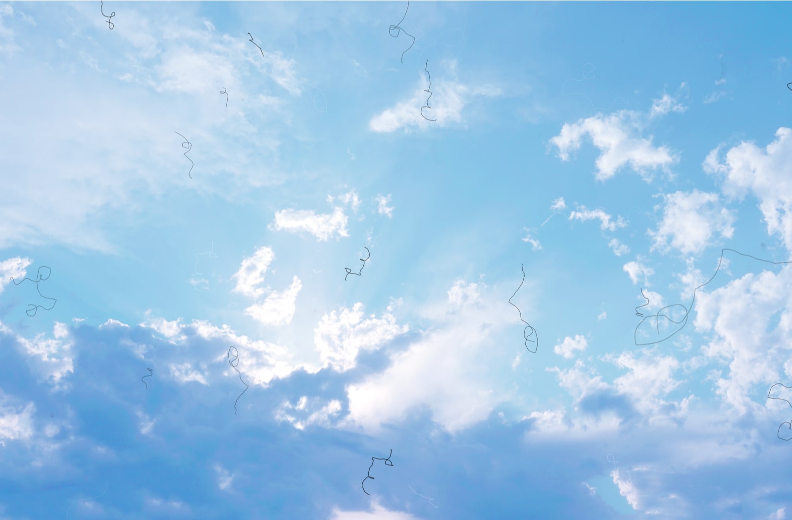 An image of a sunny sky with clouds, with lines and squiggles over the image to show what eye floaters look like