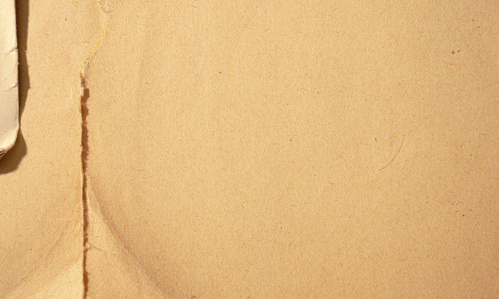 Close up image of unbleached kraft paper, brown in colour, with small rip along left hand side