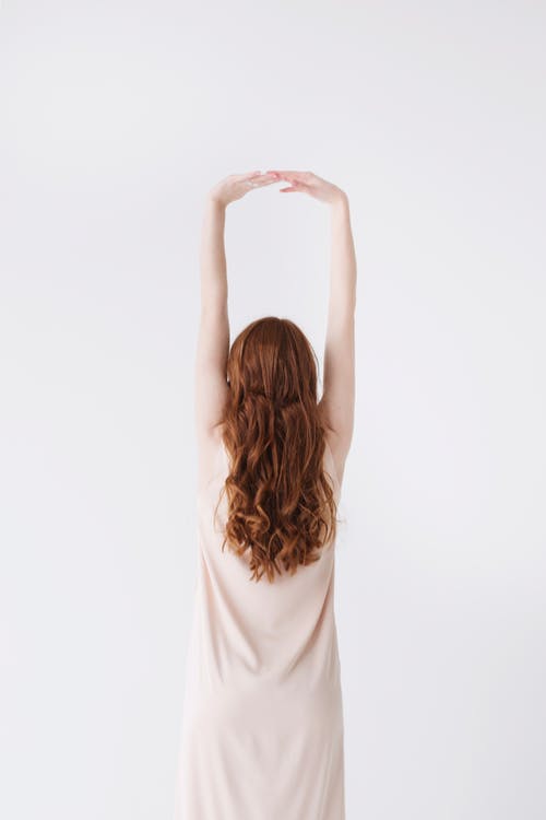 Woman in Beige Dress Stretching Her Hands