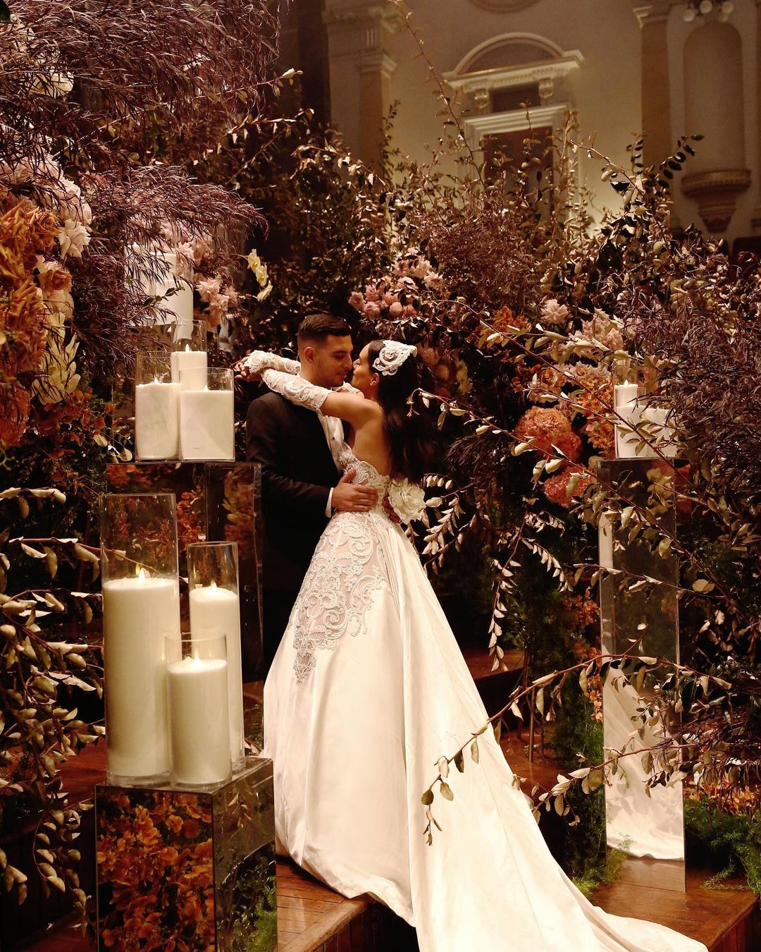 The newlywed couple amidst the florals and some romantic candles by Diane Khoury.