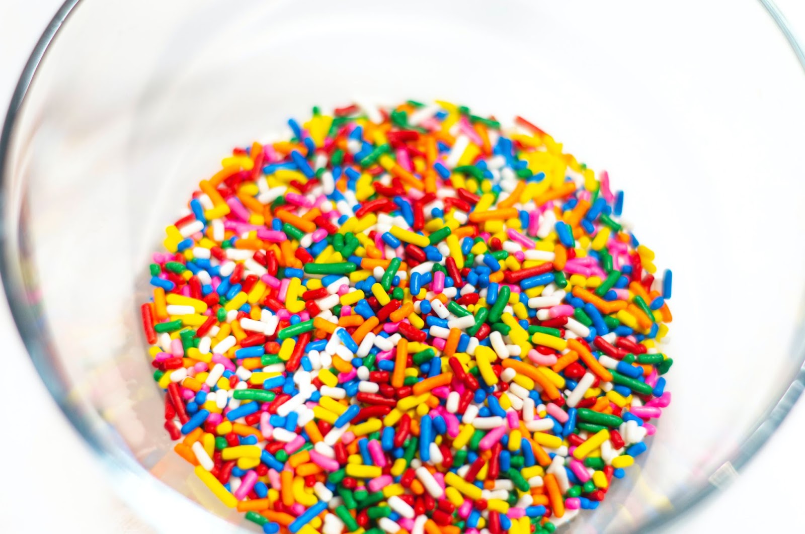 multi-coloured ice cream sprinkles in a clear glass bowl