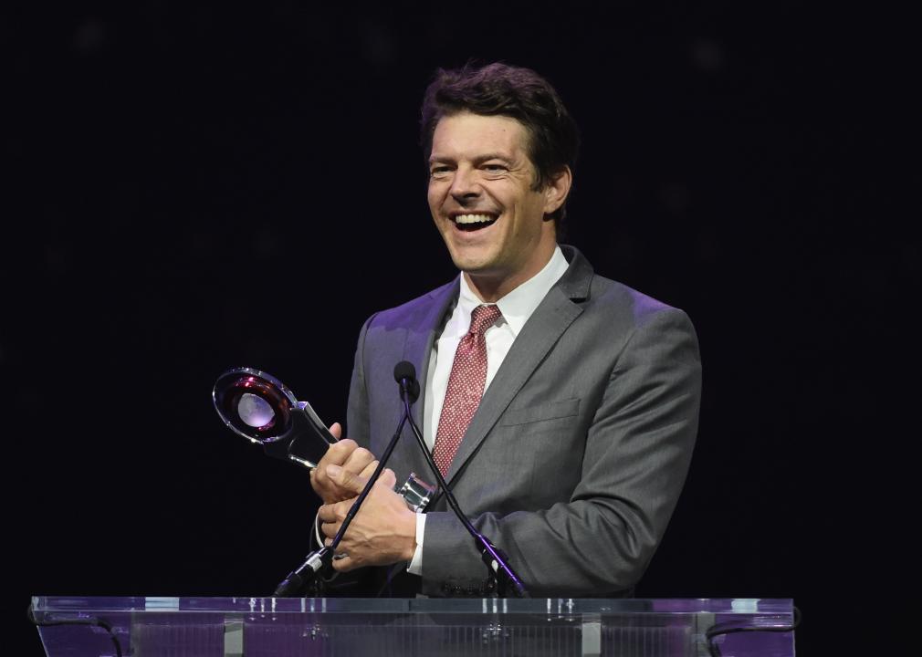 Jason Blum holding award on stage