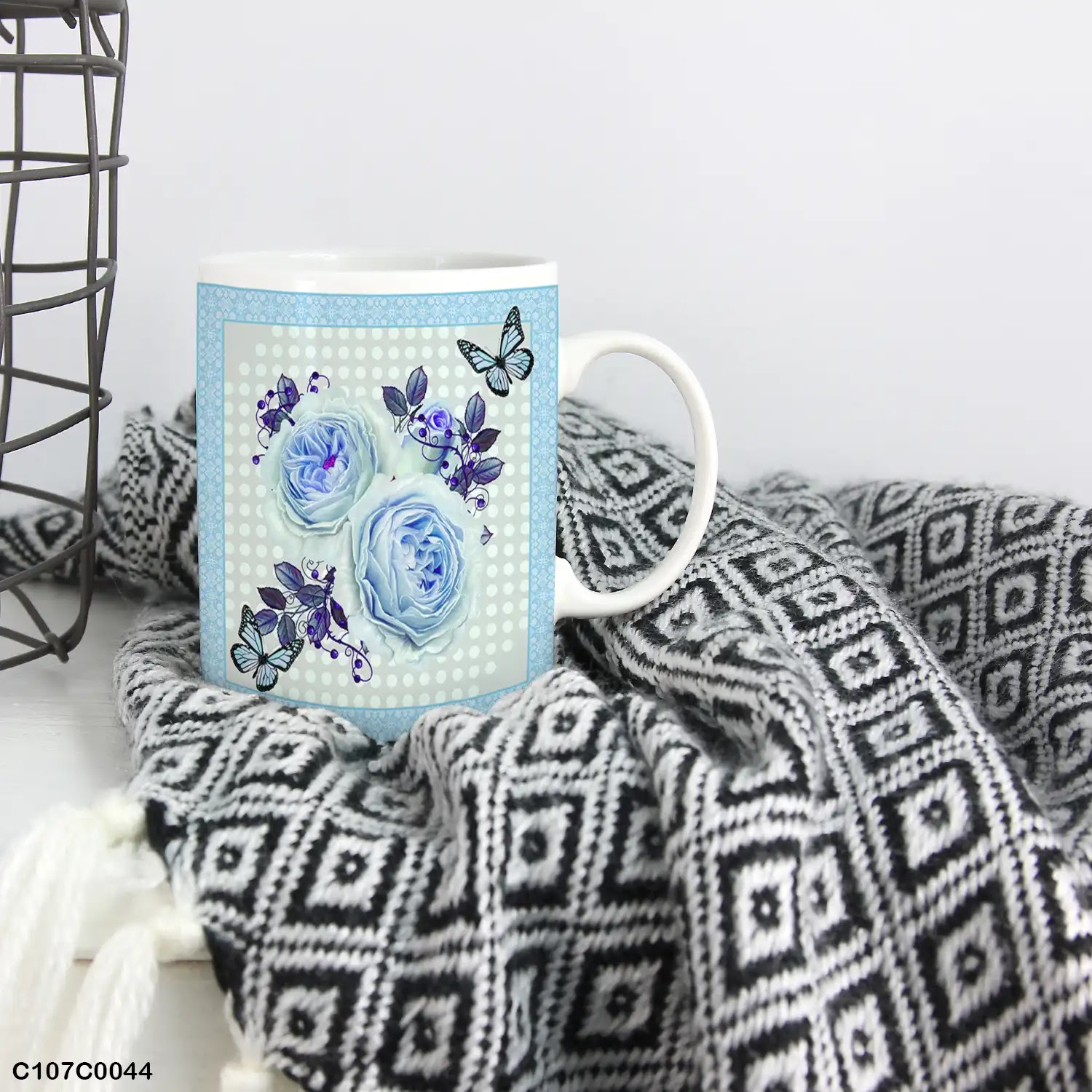 A blue mug (cup) printed with an image of blue flowers and butterflies