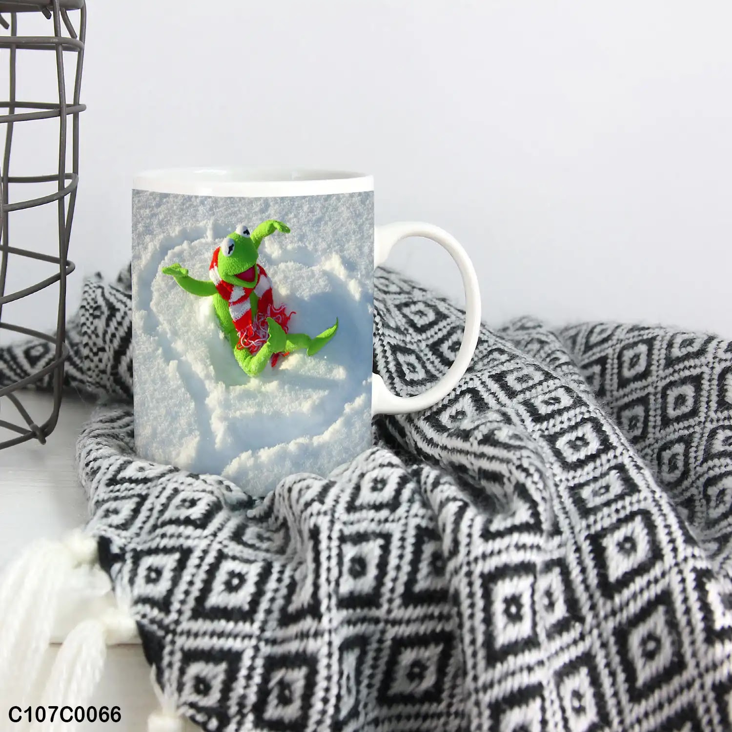 A mug (cup) printed with an image of a frog playing over a snow