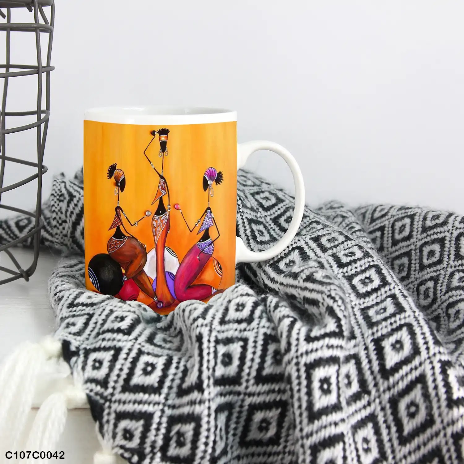 An orange mug (cup) printed with an image of African women