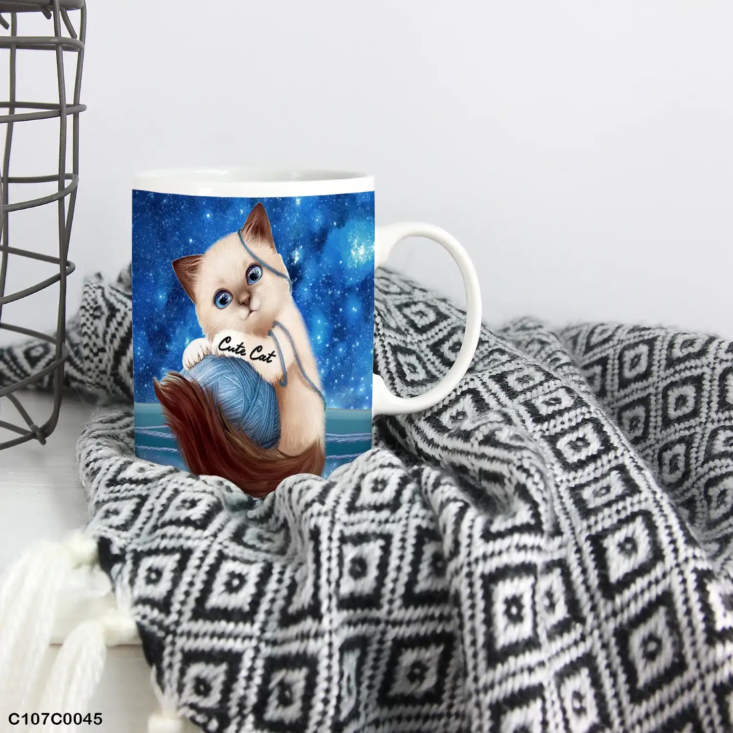 A mug (cup) printed with an image of a cat playing with wool