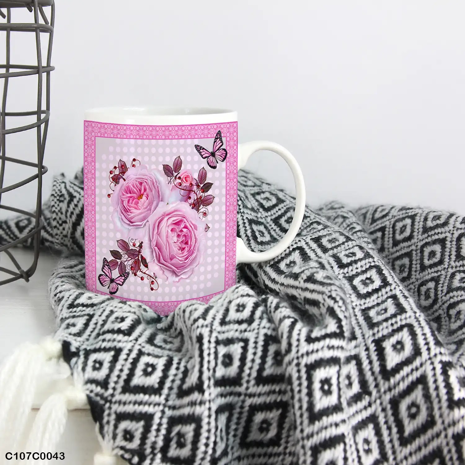 A pink mug (cup) printed with an image of pink flowers and butterflies