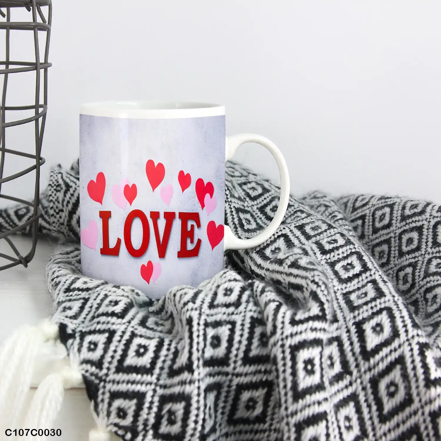 A mug (cup) printed with "LOVE" and small hearts