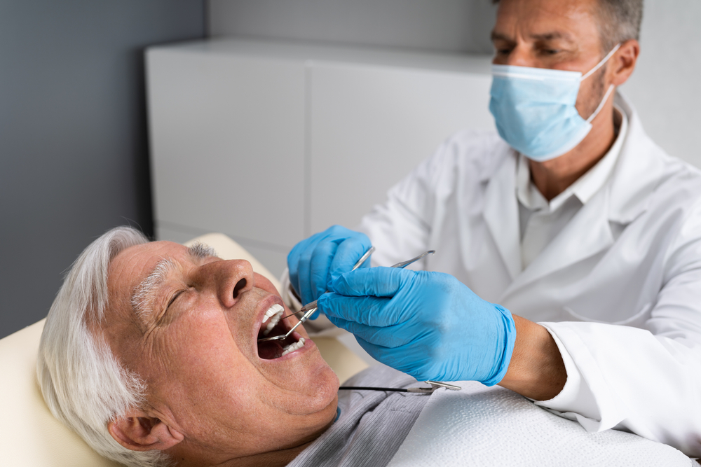 Senior man having teeth examined at dentist.
