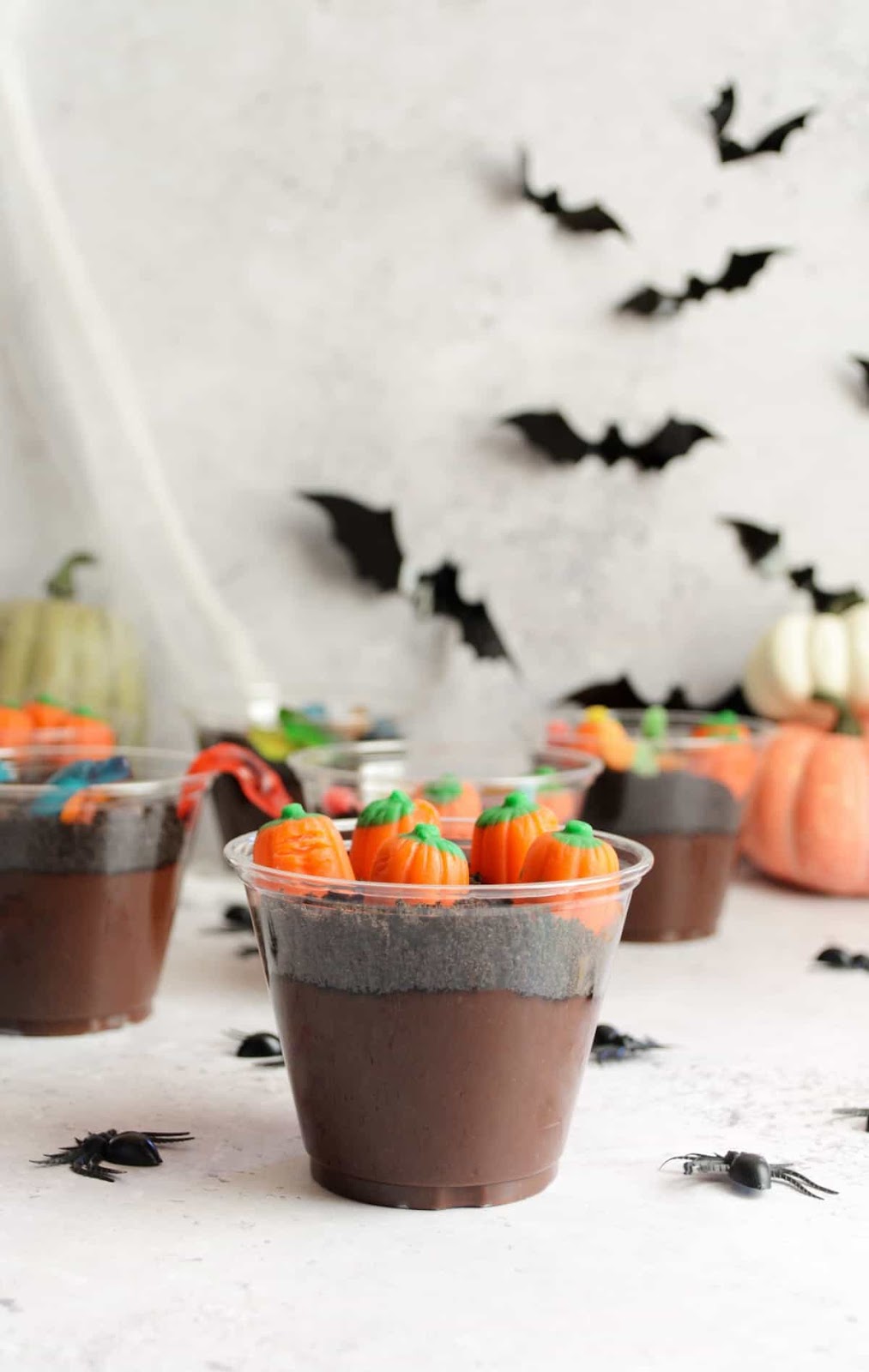 Dirt cups shown in plastic cups, decorated with candy corn pumpkins.