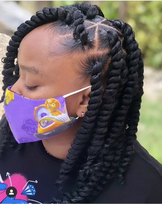 Side view of a lady rocking this hairdo paired with a steatement accessory