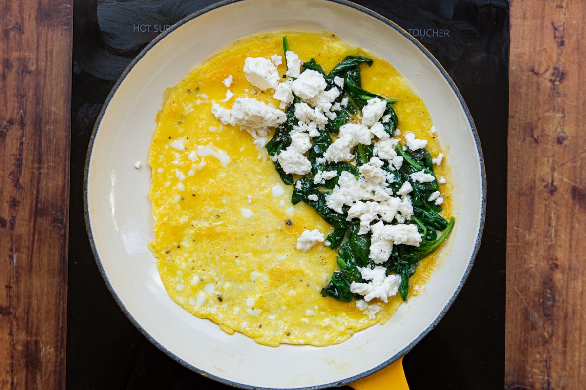 feta cheese and wilted spinach added on one side of the cooked eggs