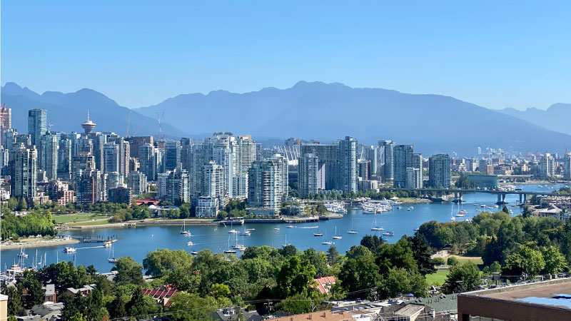 Sailboats dot the waters surrounding Vancouver, British Columbia, and mountains rise up in the distance.