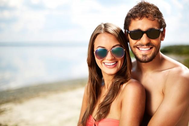 Couple with sunglasses on the beach Free Photo