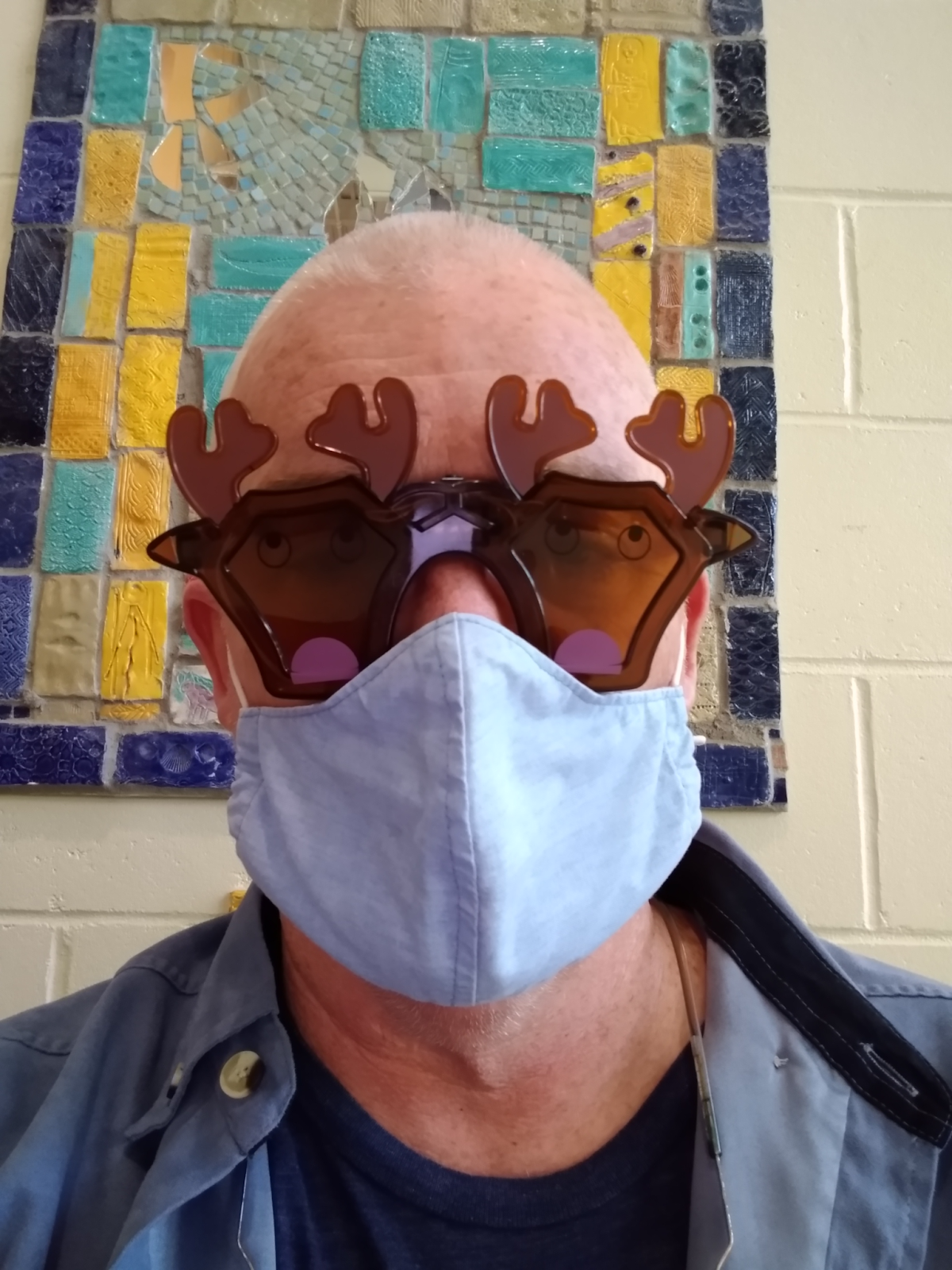 staff member with reindeer glasses and a mask
