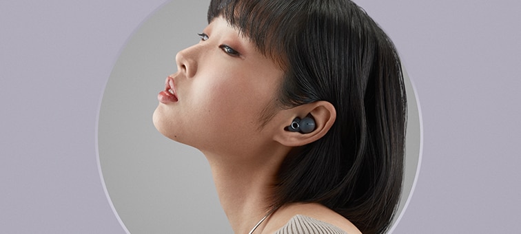 Side view of a woman listening to grey LinkBuds
