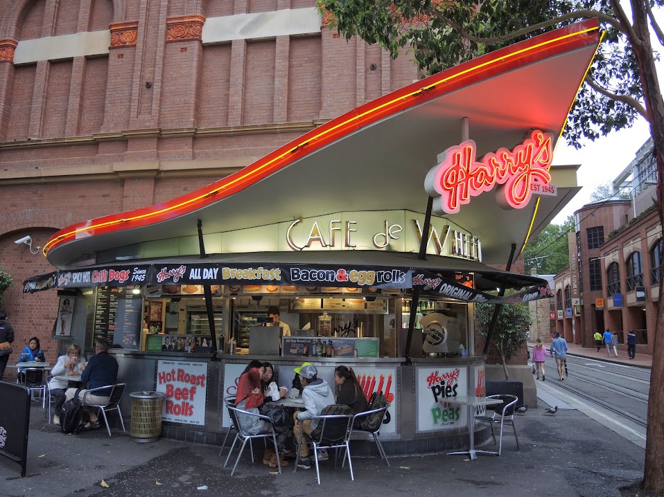 a food stand with people sitting at tables outside