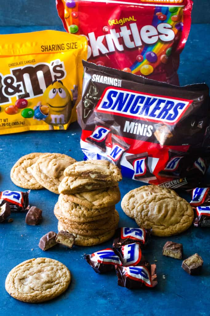 stacked snickers stuffed peanut butter cookies with candy bags in background