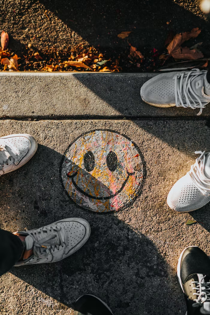 A smiley face is colorfully drawn on the pavement.