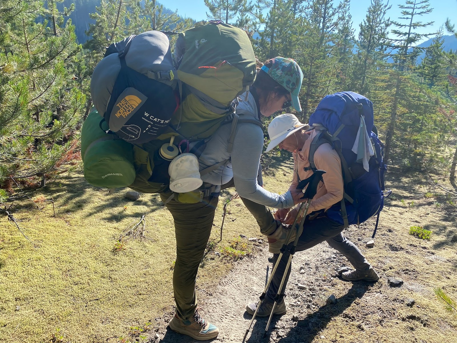 hiker helping hiker tie shoes