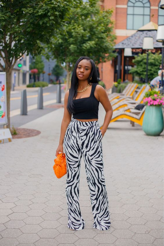lady wearing black top with print pants
