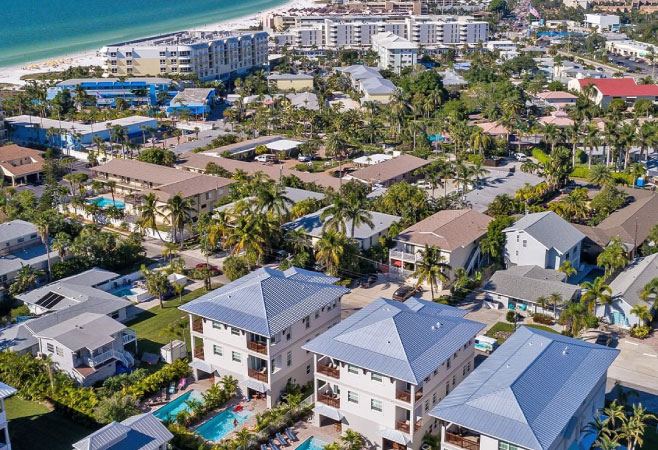 An aerial shot of a residential area of Siesta Key with the beach and ocean in the background.