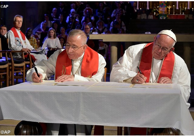 Pope Francis and Bishop Mounib Younan sign the Joint Statement in Lund's Cathedral - AP