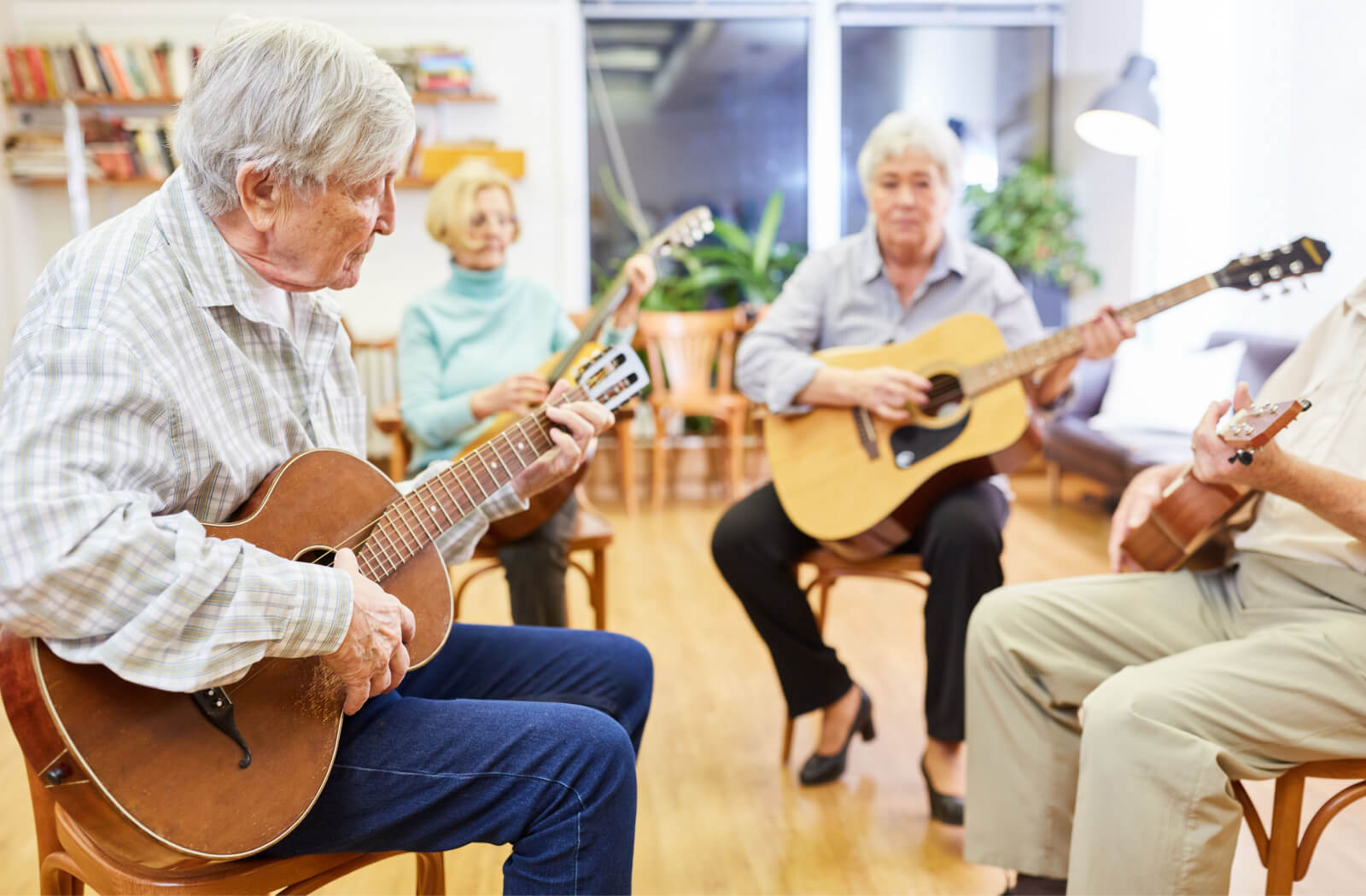 A group of seniors are playing guitars in the music room.