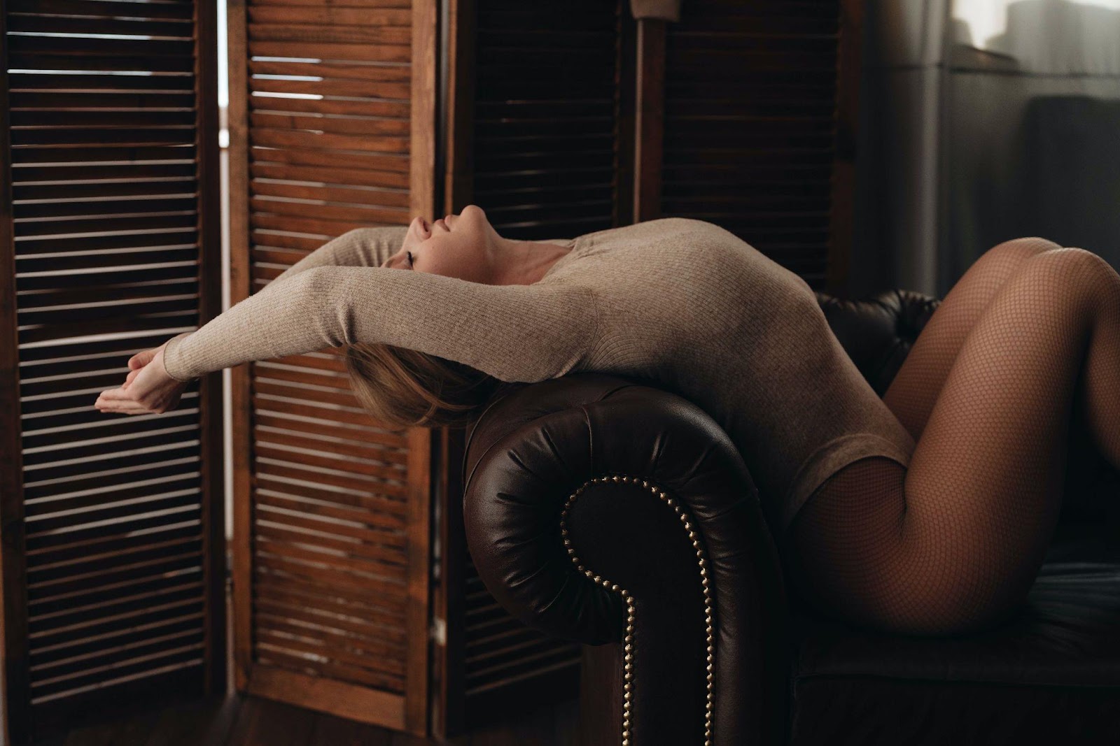 Woman sitting on a sofa in a bodysuit