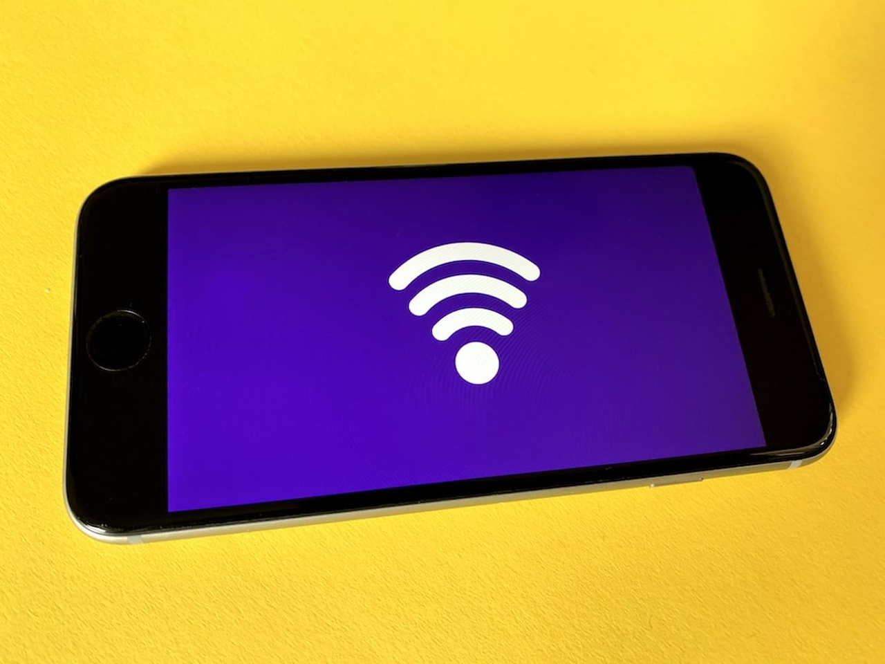 a wireless icon on a purple background of a mobile phone on the yellow background