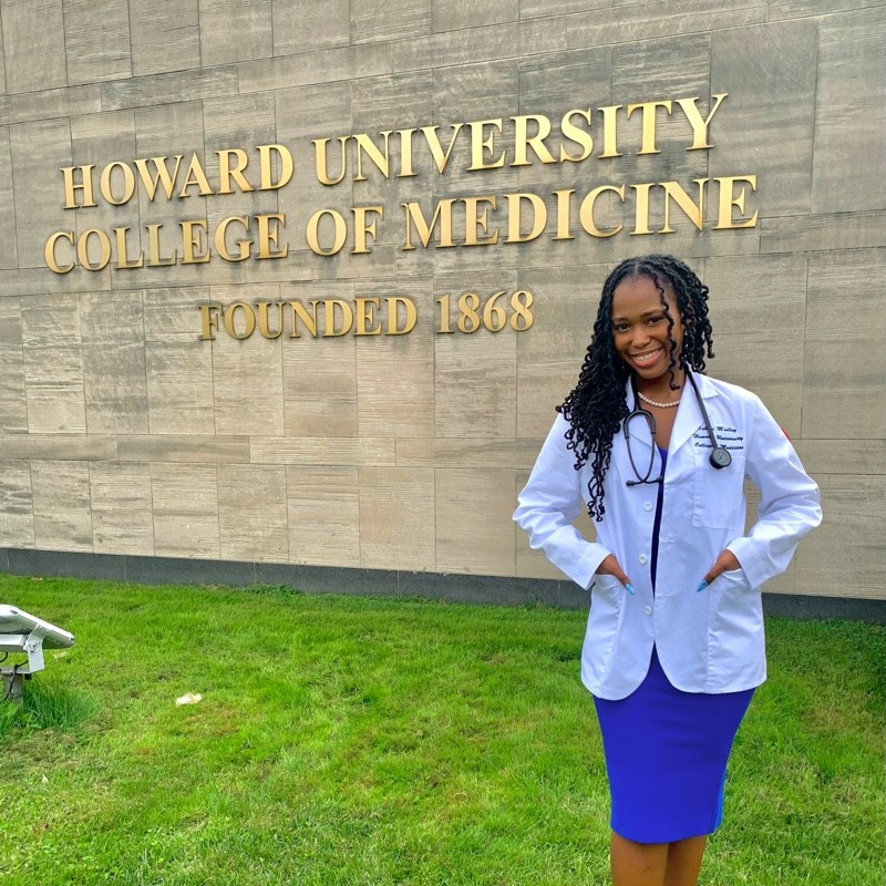 A headshot photograph of a Howard University College of Medicine student, smiling and wearing a white lab coat with a stethoscope around their neck.