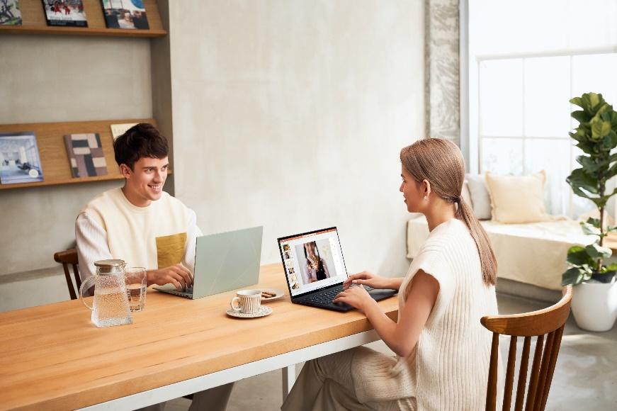 Two people sitting at a table with a computer

Description automatically generated with medium confidence