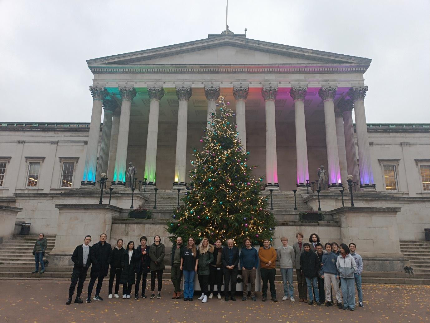 A group of people standing in front of a building with columns

Description automatically generated with medium confidence