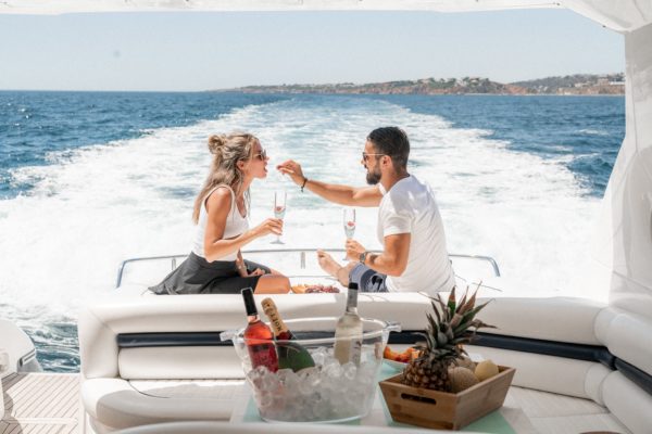 a couple sitting on a yacht drinking champagne