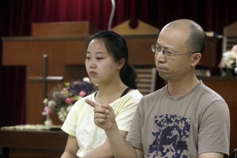 中國四川成都秋雨聖約教會有逾百名信徒在去年底被捕,來自該教會的49歲廖強(右)帶著5名家庭成員來台尋求赴美避難,圖為廖強與女兒任瑞婷(左)。(美聯社)