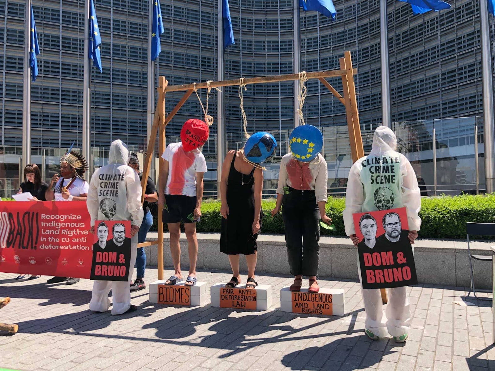 A mock hanging, each victim wearing a mask representing something at risk from the deforestation bill - indigenous people, the planet, the EU nations