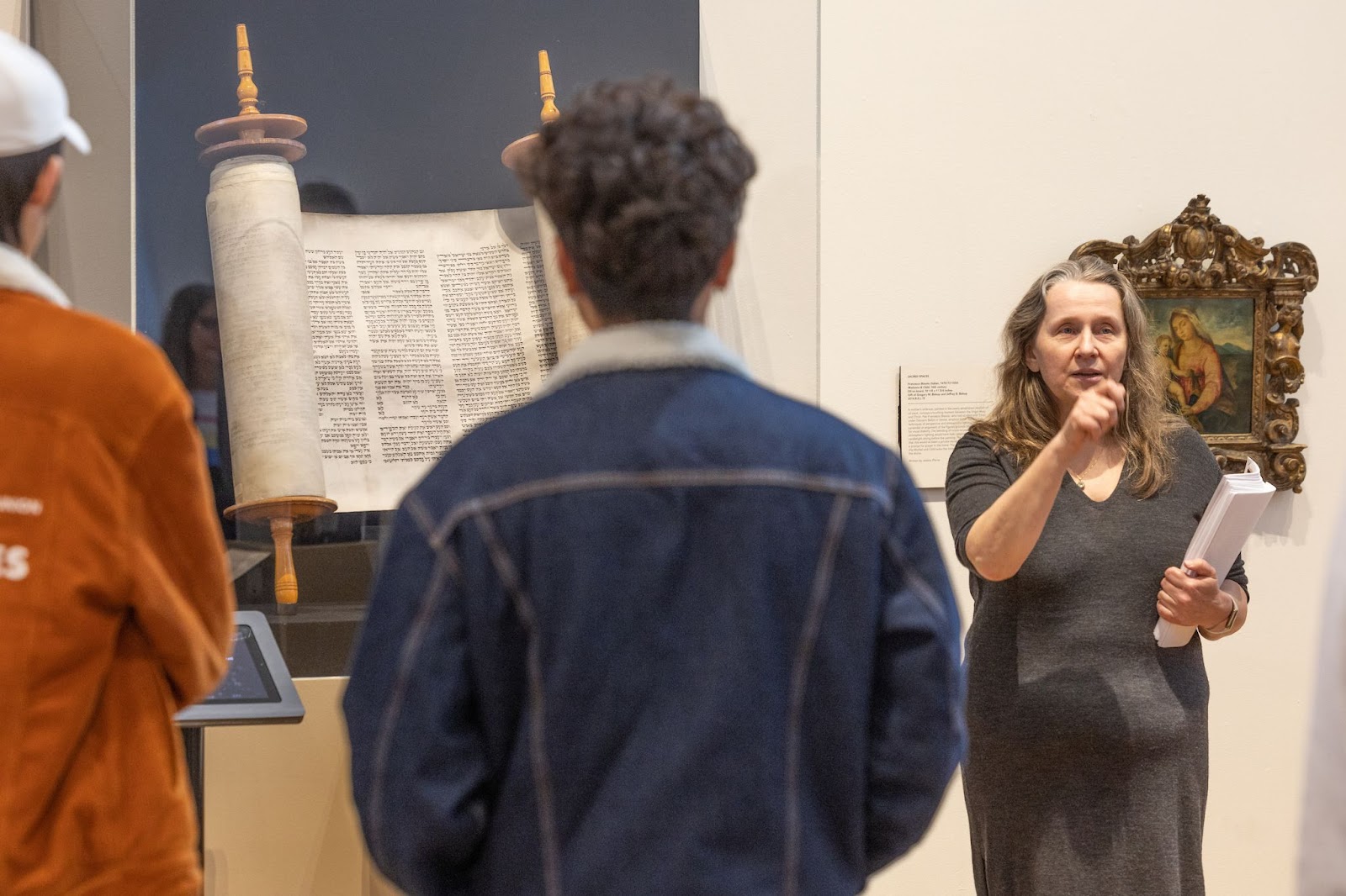 Photo of professor Anna Klosowska teaching two students in the art museum gallery for the global book lab
