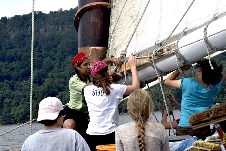 Participants of Young Women at the Helm 2019 cleaning up sail after the hard work of raising it!