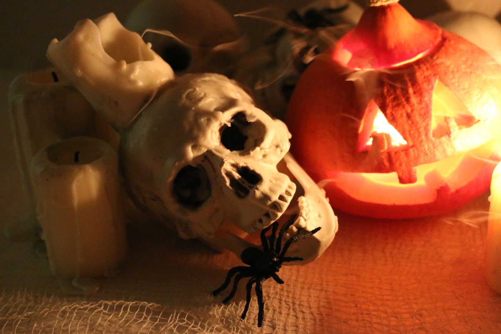 Halloween setting with candles, jack o' lantern, skull, spider