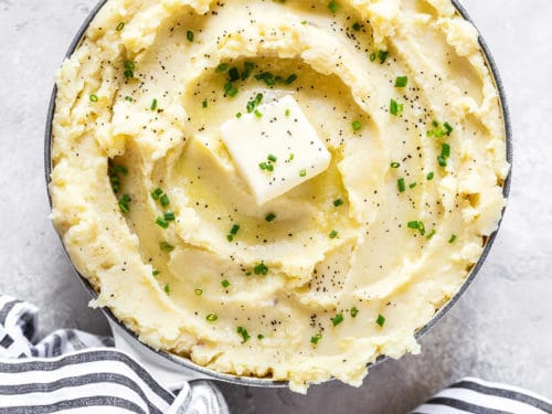 Bowl of creamy mashed potatoes garnished with parsley 
