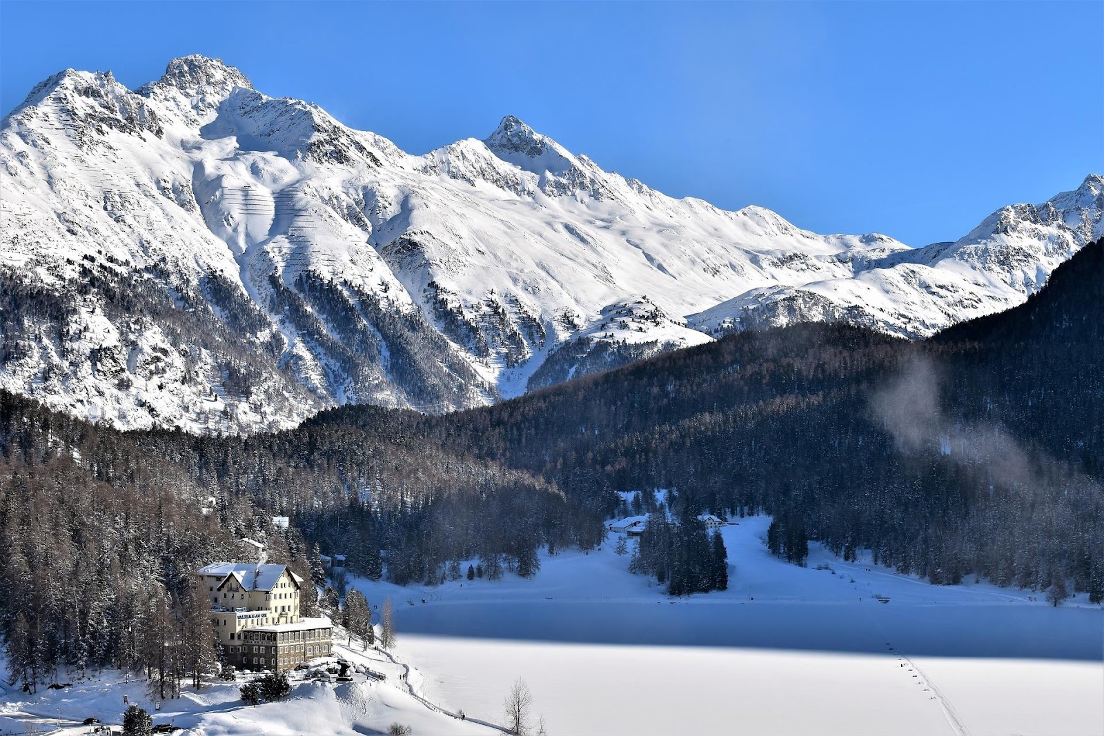 saint moritz ski resort hotel in winter frozen lake alps in background switzerland