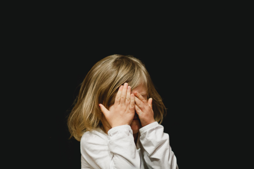 A child covering her face with her hands
Description automatically generated with medium confidence