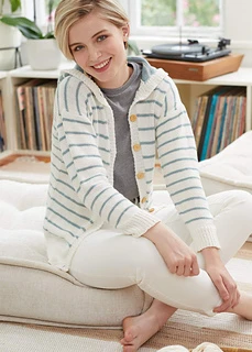 lady wearing striped hoodie sitting on cushion inside