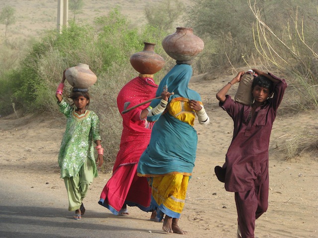 Women are responsible for providing water for their families. Many spend hours travelling to the wells and back home every day, carrying heavy clay pots on their heads. Credit: Irfan Ahmed/IPS