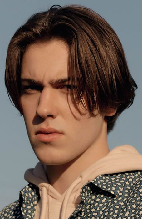 Close up view of a guy rocking the middle part hairstyle