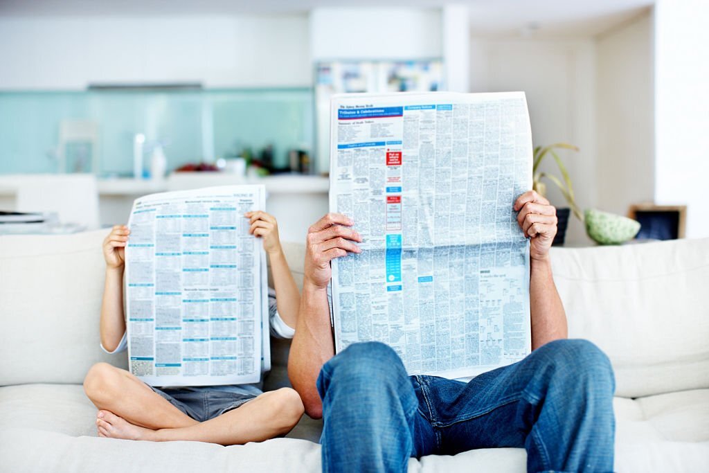  father and son reading newspaper

