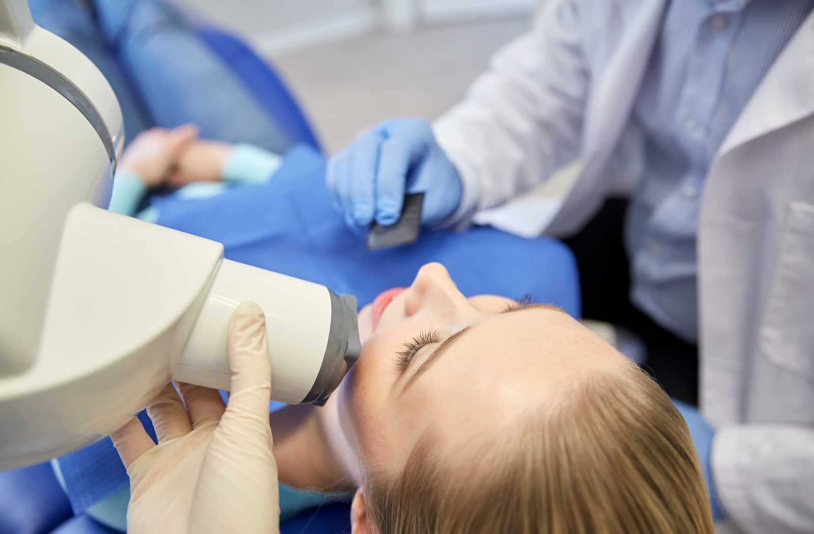 young woman receiving panoramic xray in her chair from overhead