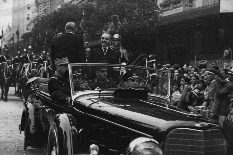 A vintage photo of a group of people in a car

Description automatically generated