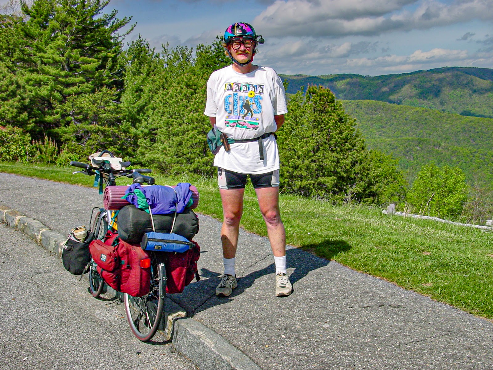 Cyclist stands by his bike wearing his helmet and Elvis t-shirt